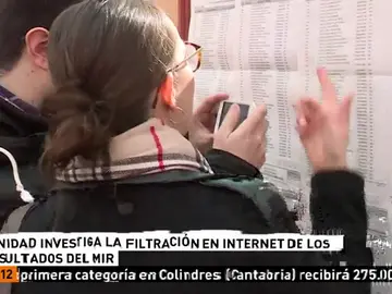 Dos personas consultan los resultados del MIR Dos personas consultan los resultados del MIR