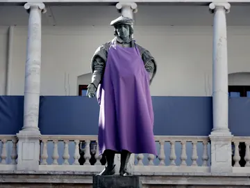 Una estatua con un delantal morado en apoyo a la huelga del 8M Una estatua con un delantal morado en apoyo a la huelga del 8M