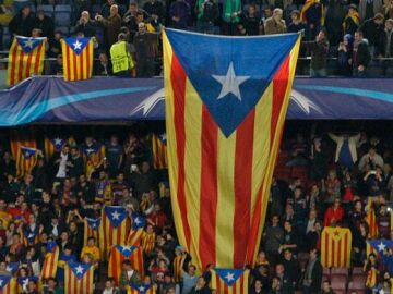 Seguidores del F.C. Barcelona despliegan esteladas en un partido de la Champions. / EFE