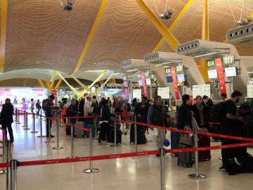 Pasajeros esperan ante los mostradores de facturación del aeropuerto de Barajas