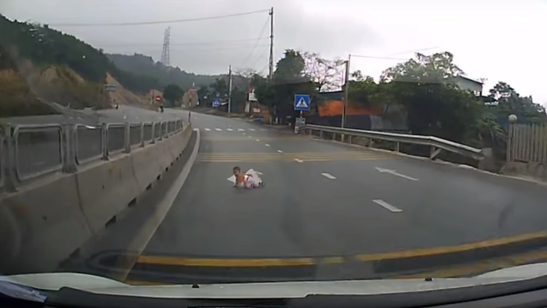 El bebé gateando en la carretera El bebé gateando en la carretera