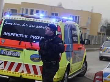 Un policía pasa cerca de una ambulancia en Praga