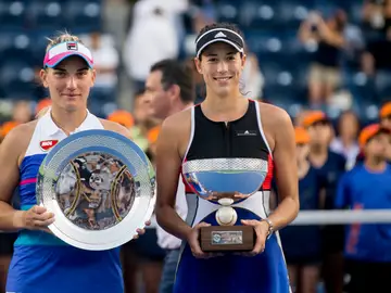 Garbiñe Muguruza sostiene su trofeo de campeona junto a Babos Garbiñe Muguruza sostiene su trofeo de campeona junto a Babos