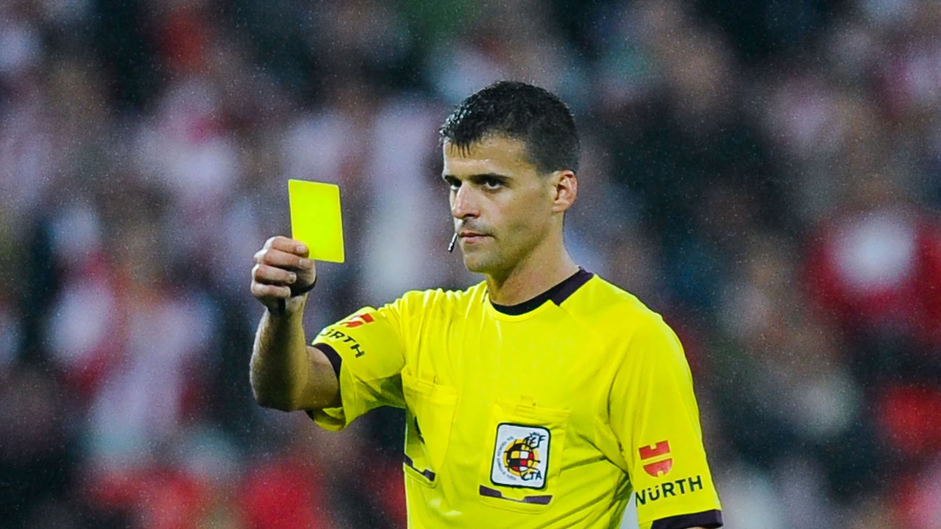 Gil Manzano muestra una tarjeta amarilla durante un partido Gil Manzano muestra una tarjeta amarilla durante un partido