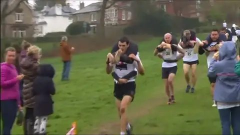 Cargan con sus parejas en una peeculiar carrera de obstáculos Cargan con sus parejas en una peeculiar carrera de obstáculos