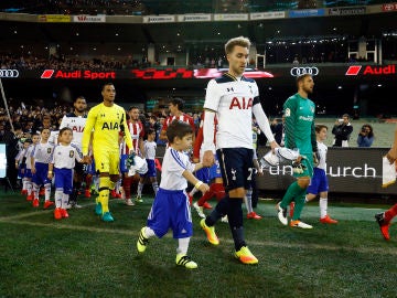 Los jugadores de Tottenham y Atlético de Madrid saltan al campo junto a niños