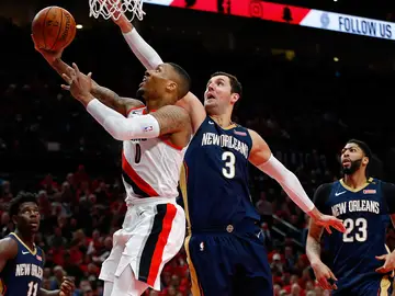 Mirotic intenta taponar a Damian Lillard en su penetración a canasta Mirotic intenta taponar a Damian Lillard en su penetración a canasta