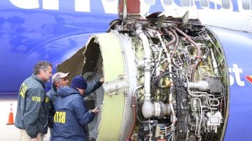 Investigadores examinando el daño a un motor del vuelo