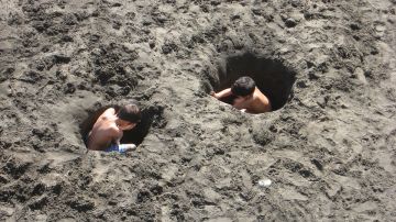 Niños cavando un agujero en la arena
