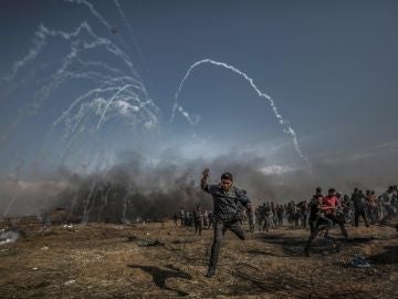 Manifestantes palestinos corren para refugiarse del gas lacrimógeno