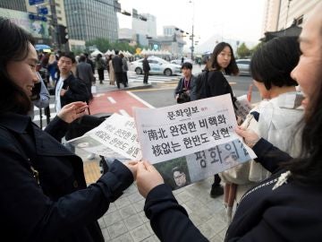Varias personas leen la edición extra de un periódico local que informa de la histórica reunión de los líderes de las dos Coreas