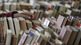 Un visitante hojea los ejemplares de una de las casetas de la XXXVI Feria del Libro Antiguo y de Ocasi&oacute;n de Madrid