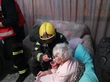 El bombero dando de comer a la anciana El bombero dando de comer a la anciana