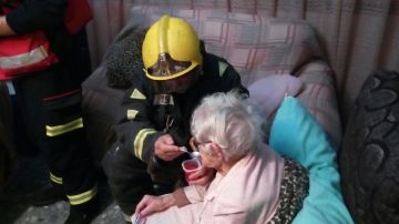 El bombero dando de comer a la anciana
