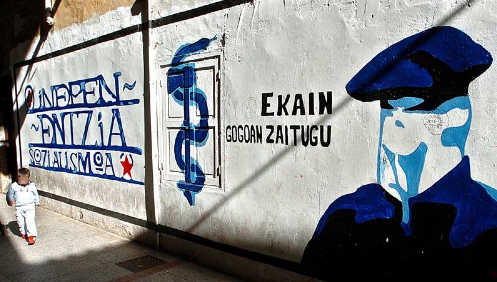 Mural que representa a un encapuchado junto al anagrama de ETA.