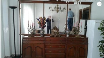 Pone en venta un mueble con espejo en el que salen dos personas reflejados