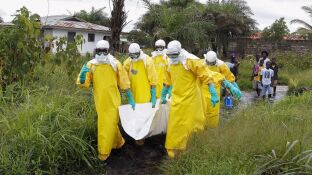 Enfermeros trasladas el cuerpo de una supuesta v&iacute;ctima del virus &eacute;bola en un &aacute;rea a las afueras de Monrovia (Liberia)