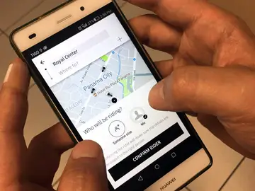 Un usuario de Uber utiliza un teléfono móvil. Un usuario de Uber utiliza un teléfono móvil.