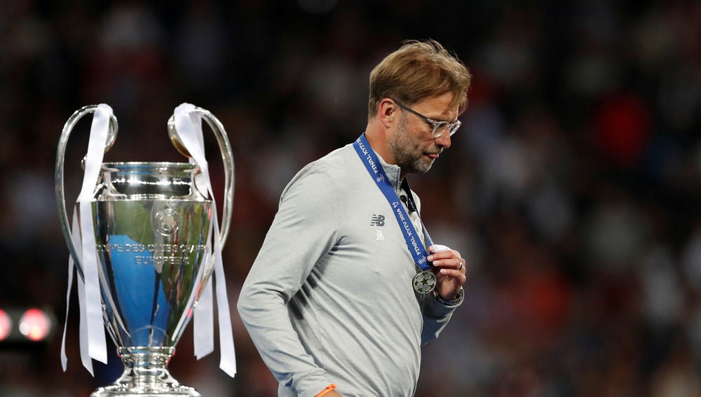 Klopp pasa al lado del trofeo de la Champions