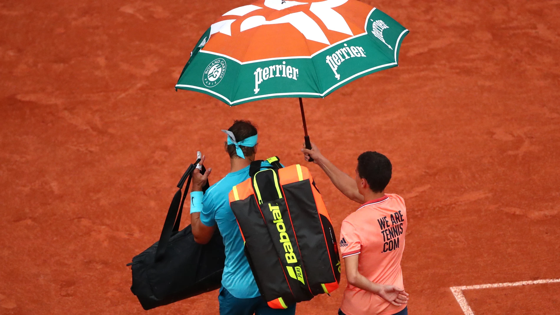 Rafa Nadal abandona la Philippe Chatrier bajo un paraguas Rafa Nadal abandona la Philippe Chatrier bajo un paraguas