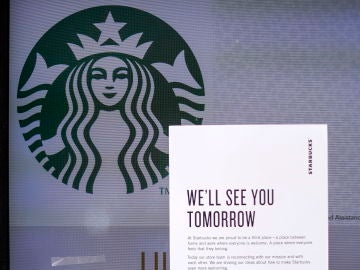 Vista de un local de Starbucks que tiene un letrero en el que se lee "Te veremos mañana"