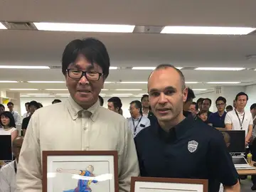 Takahashi posa con Iniesta y sus dos dibujos Takahashi posa con Iniesta y sus dos dibujos