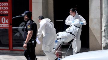La policía científica saca el cadáver de la mujer que ha fallecido