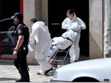 Momento en el que la policía científica saca el cadáver de la mujer fallecida en Albacete