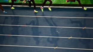Varios atletas corren en una pista de atletismo
