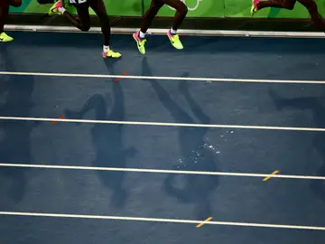 Varios atletas corren en una pista de atletismo Varios atletas corren en una pista de atletismo