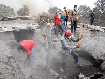 Un grupo de personas retira escombros en un intento por encontrar a algunos de sus familiares desaparecidos en Guatemala Un grupo de personas retira escombros en un intento por encontrar a algunos de sus familiares desaparecidos en Guatemala