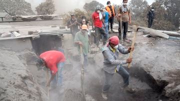 Un grupo de personas retira escombros en un intento por encontrar a algunos de sus familiares desaparecidos en Guatemala