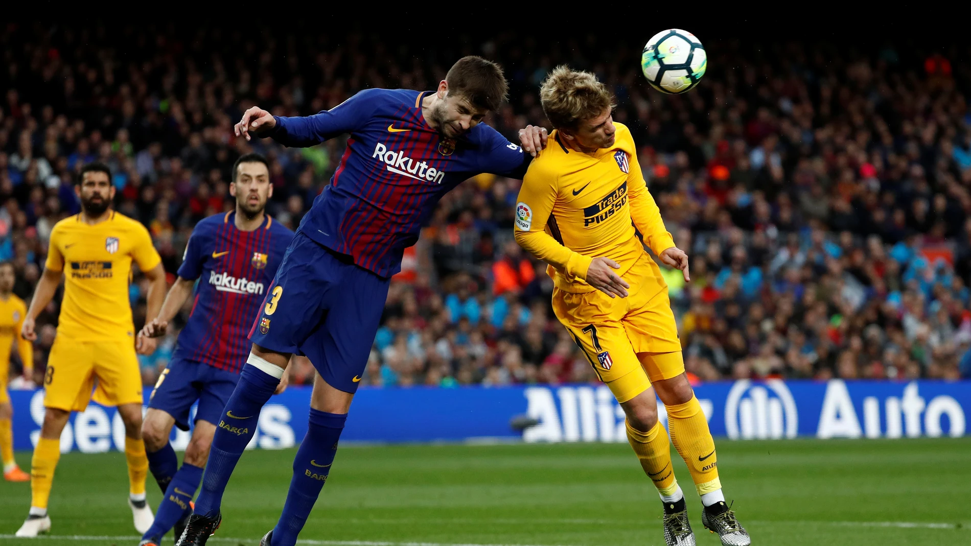 Piqué y Griezmann se disputan el balón por alto Piqué y Griezmann se disputan el balón por alto