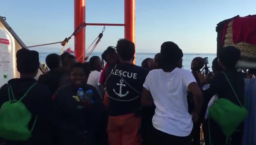 Sonrisas, cánticos y saludos de los migrantes de la flota del Aquarius al llegar al puerto de Valencia