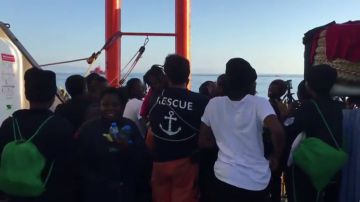 Sonrisas, cánticos y saludos de los migrantes de la flota del Aquarius al llegar al puerto de Valencia