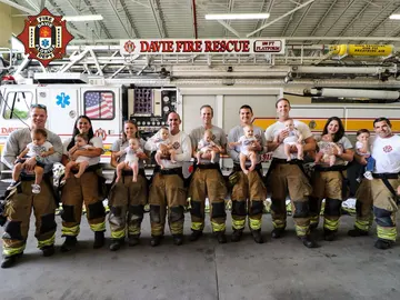 Padres y madres vestidos de bomberos con sus bebés Padres y madres vestidos de bomberos con sus bebés