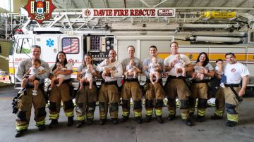 Padres y madres vestidos de bomberos con sus bebés