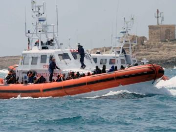 Un grupo de inmigrantes en un bote de la Guardia Costera italiana