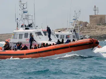 Un grupo de inmigrantes en un bote de la Guardia Costera italiana Un grupo de inmigrantes en un bote de la Guardia Costera italiana