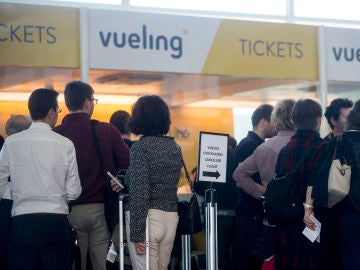 Varios viajeros en los mostradores de la aerolínea Vueling