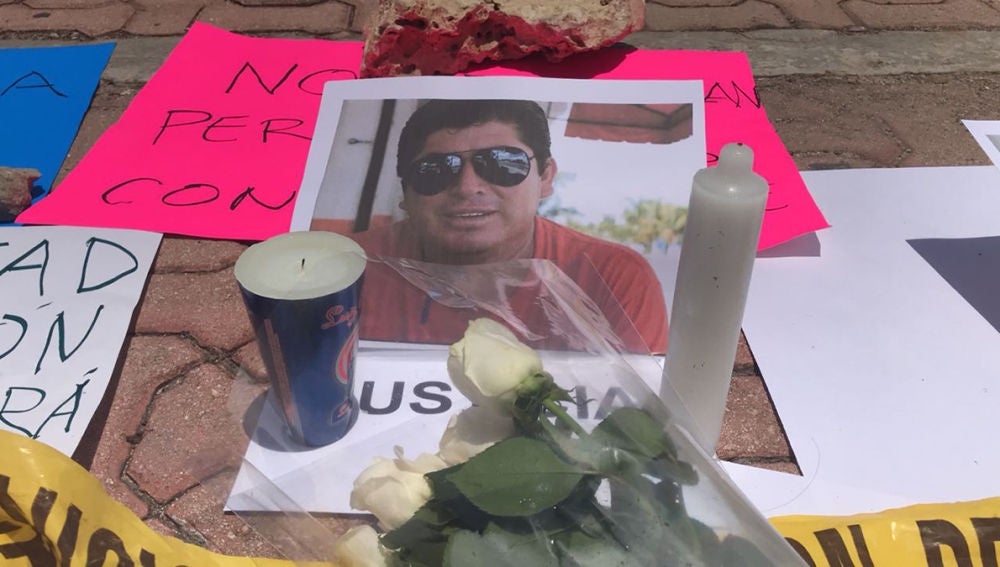 Flores ante un retrato del periodista mexicano asesinado