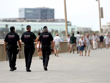 Tres Mossos d'Esquadra patrullan por el paseo marítimo de Barcelona Tres Mossos d'Esquadra patrullan por el paseo marítimo de Barcelona