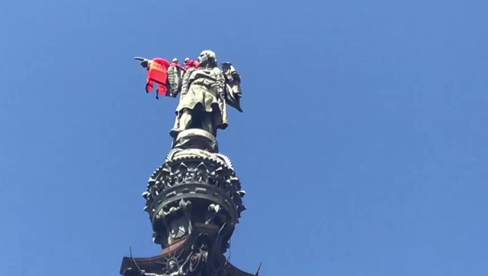 Los activistas de Open Arms colocan un chaleco salvavidas a la estatua de Colón en Barcelona
