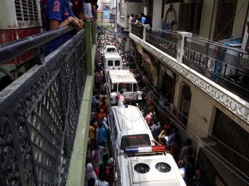 Las ambulancias esperan para llevarse los cuerpos de los 11 miembros de la familia que se ha suicidado en la India