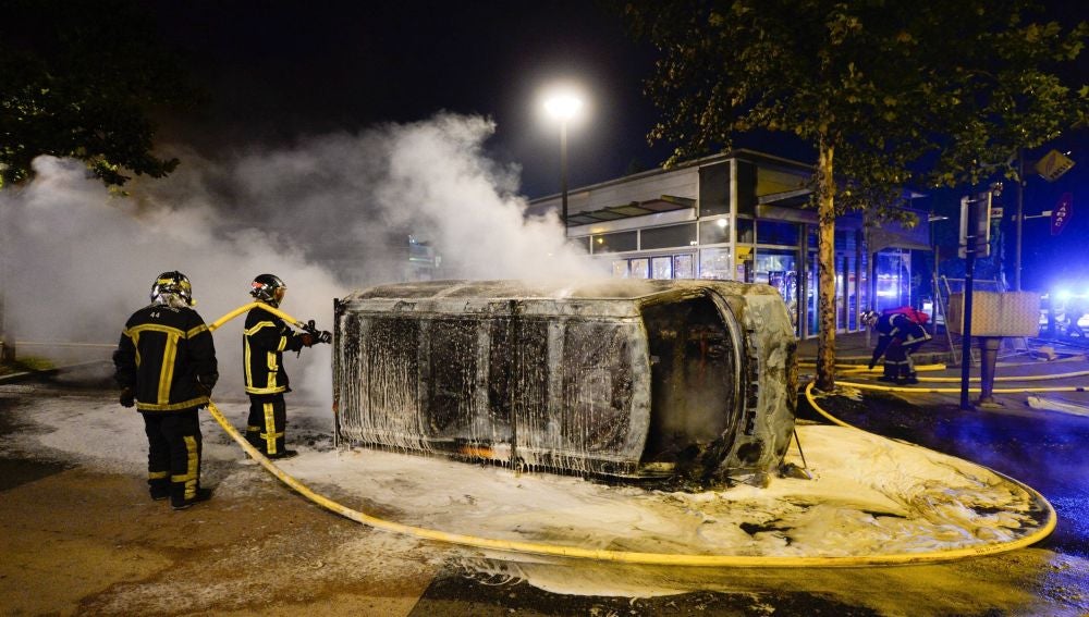 Bomberos trabajan en la extinción de un incendio en un vehículo durante la noche del 3 de julio