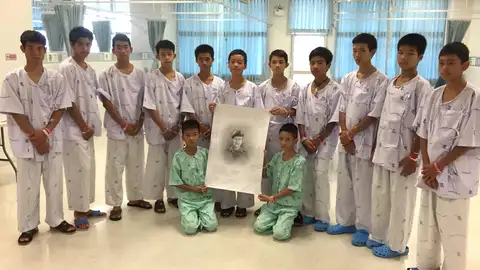 Los niños rescatados de la cueva posan junto a un retrato del buzo fallecido Los niños rescatados de la cueva posan junto a un retrato del buzo fallecido