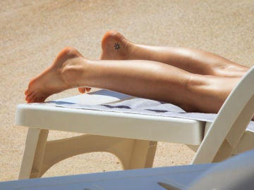 Mujer con tatuaje toma el sol