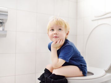 Niño sentado en urinario