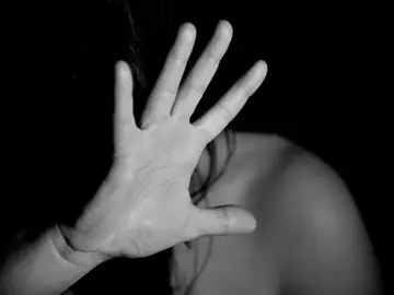 Una mujer se tapa el rostro Una mujer se tapa el rostro