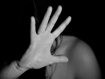 Una mujer se tapa el rostro Una mujer se tapa el rostro